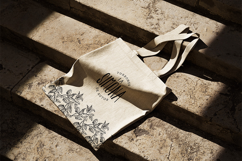 Tote Bag con logo de La Simona e ilustraciones.